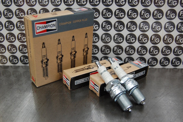 Photo of a pair of Champion N3C spark plugs used in vintage Triumph motorcycles with Franz and Grubb logo in background