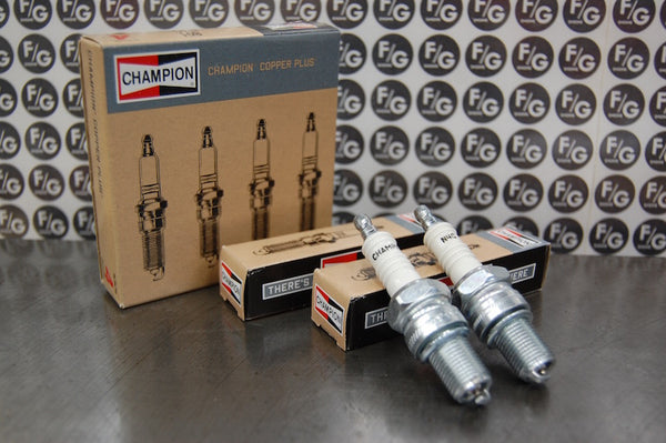 Photo of a pair of Champion N4C spark plugs used in vintage Triumph motorcycles with Franz and Grubb logo in background