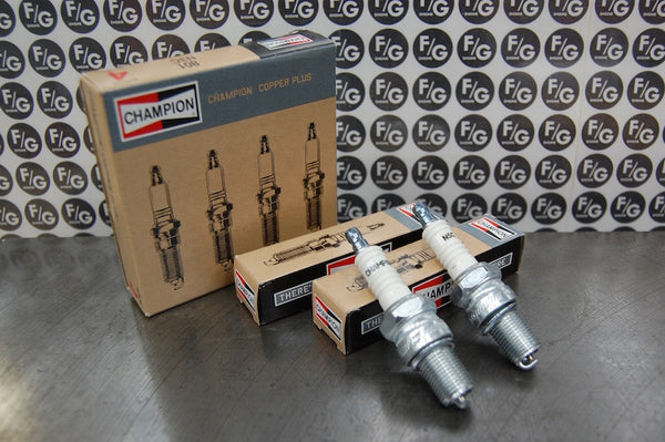 Photo of a pair of Champion N5C spark plugs used in vintage Triumph motorcycles with Franz and Grubb logo in background